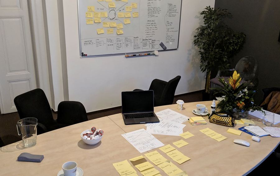 A room after a workshop: a whiteboard, sticky notes, and papers on the table